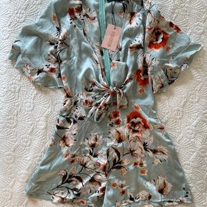 Deep plunging floral satin romper with tie and ruffle detail